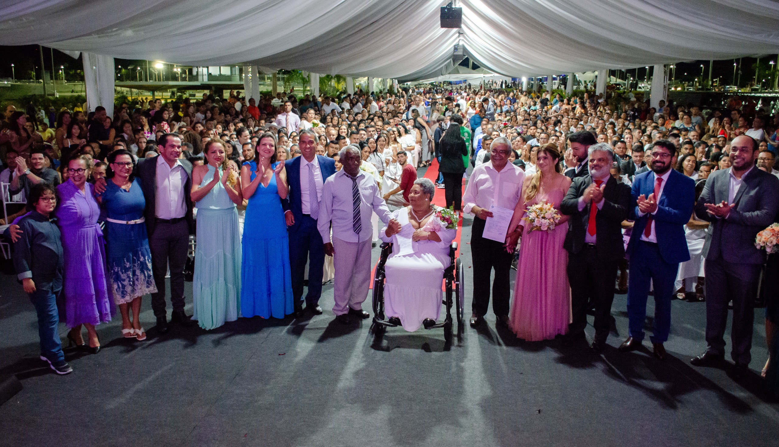 Foto colorida mostra aproximadamente 260 pessoas durante uma cerimônia de caamento coletivo 