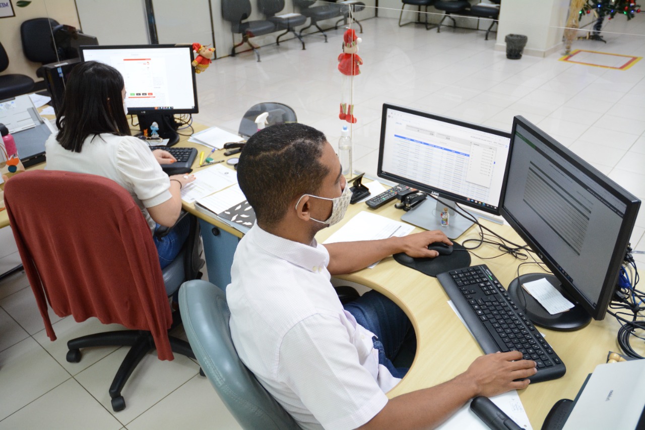 Imagem de servidores do TJRR sentados na frente dos computadores trabalhando durante Mutirão de Conciliação.