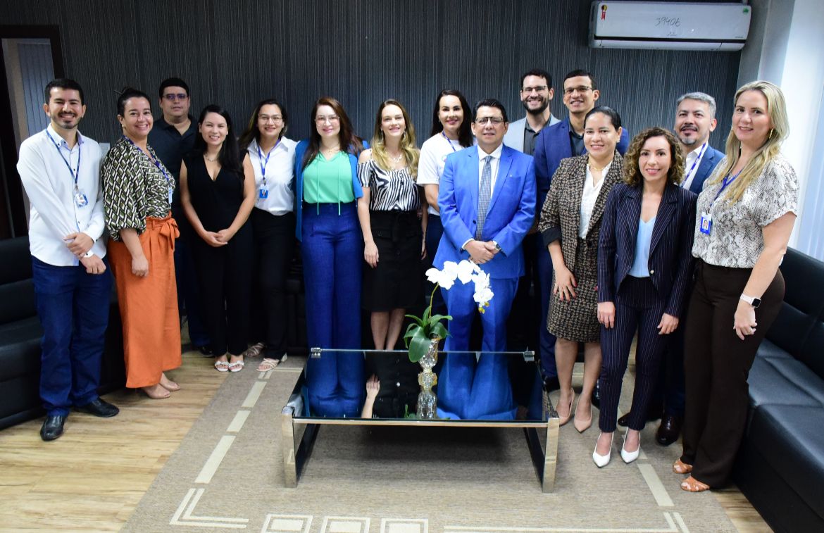 Imagem colorida mostra o presidente do TJRR, desembargador Jésus Nascimento, em pé posando para a foto ao lado de 13 servidores, entre os quais estão os  secretários e coordenadores da instituição.