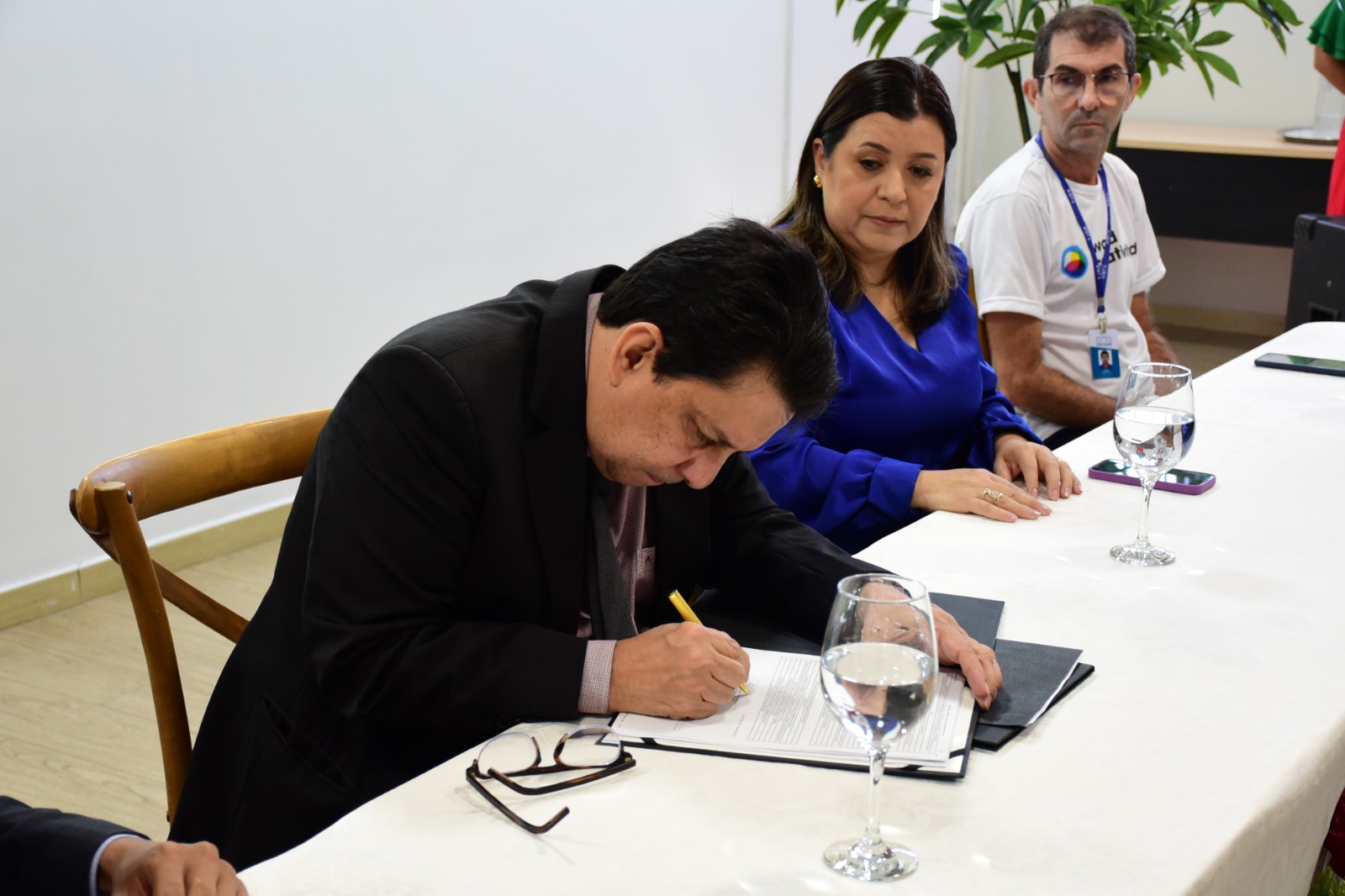foto colorida do presidente do TJRR, desembargador Jésus Nascimento em uma mesa diretiva assinando um papel