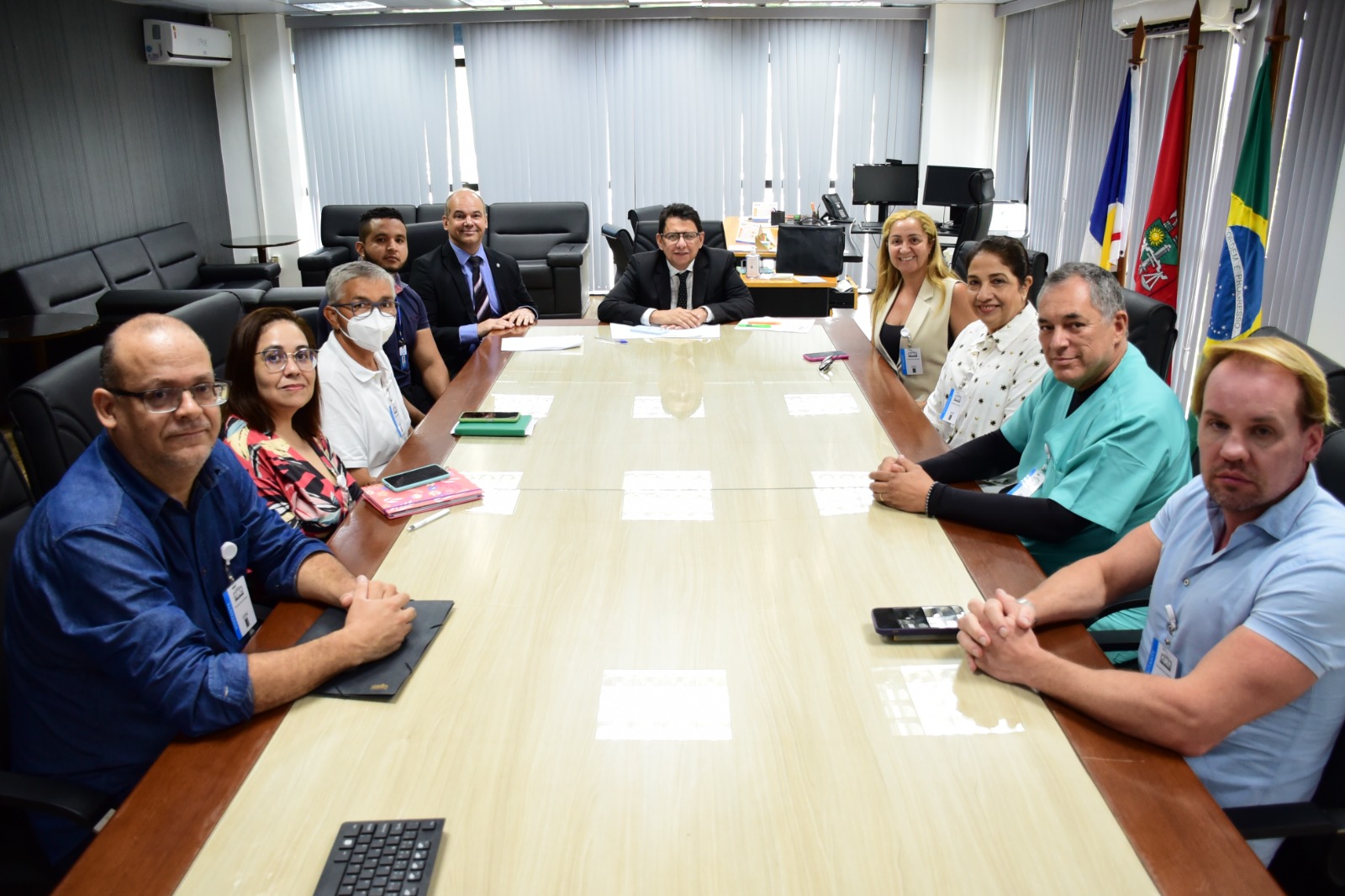 foto colorida na sala da presidencia com o Presidente do TJRR, des Jésus Nascimento juntamente com mais servidores em uma mesa de reunião
