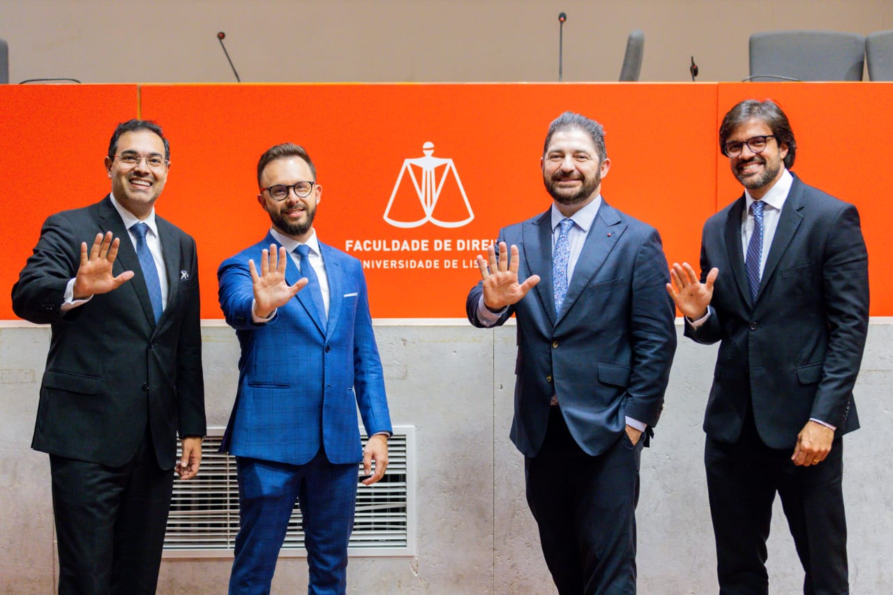 foto colorida do juiz auxiliar da presidência pousando para a foto junto com mais 3 homens. Todos estão fazendo high five