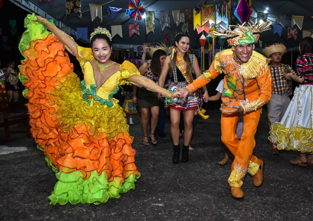 foto colorida mostra casal de quadrilheiros dançando na primeira edição do arraial da saúde, realizado pelo TJRR em 2023. Ambos trajam com  roupas típicas de festa junina.