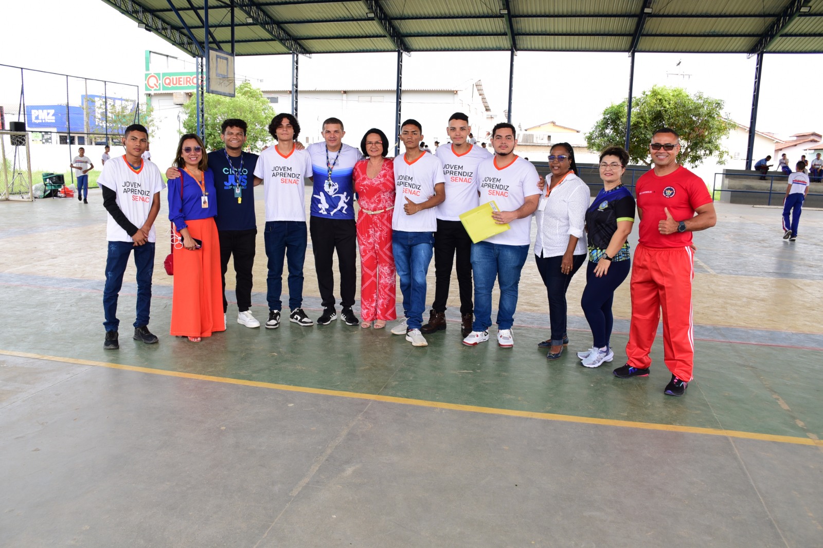 foto colorida de 13 pessoas pousando para foto em uma quadra esportiva