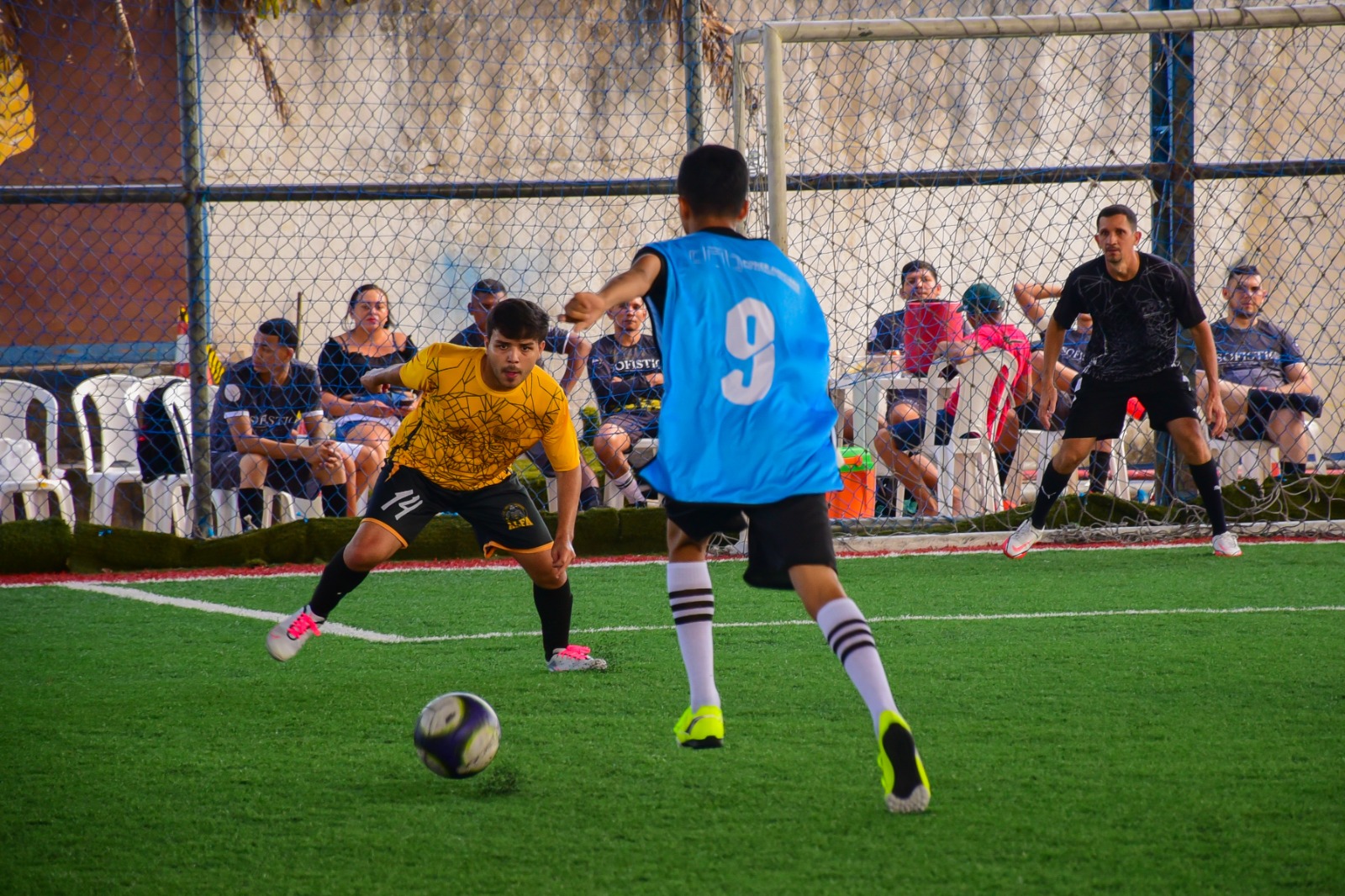 foto de um jogador chutando a bola e outro pronto para defender