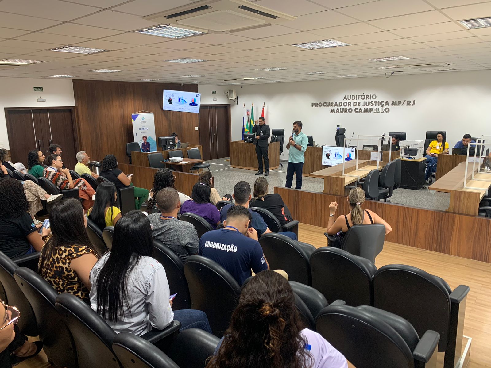  foto colorida mostra quinze pessoas, entre servidores do TJRR e os enfermeiros da Faculdade Estácio, durante atendimento num corredor do Fórum Criminal Ministro Evandro Lins e Silva, durante “Ação Cuidando do Servidor”.