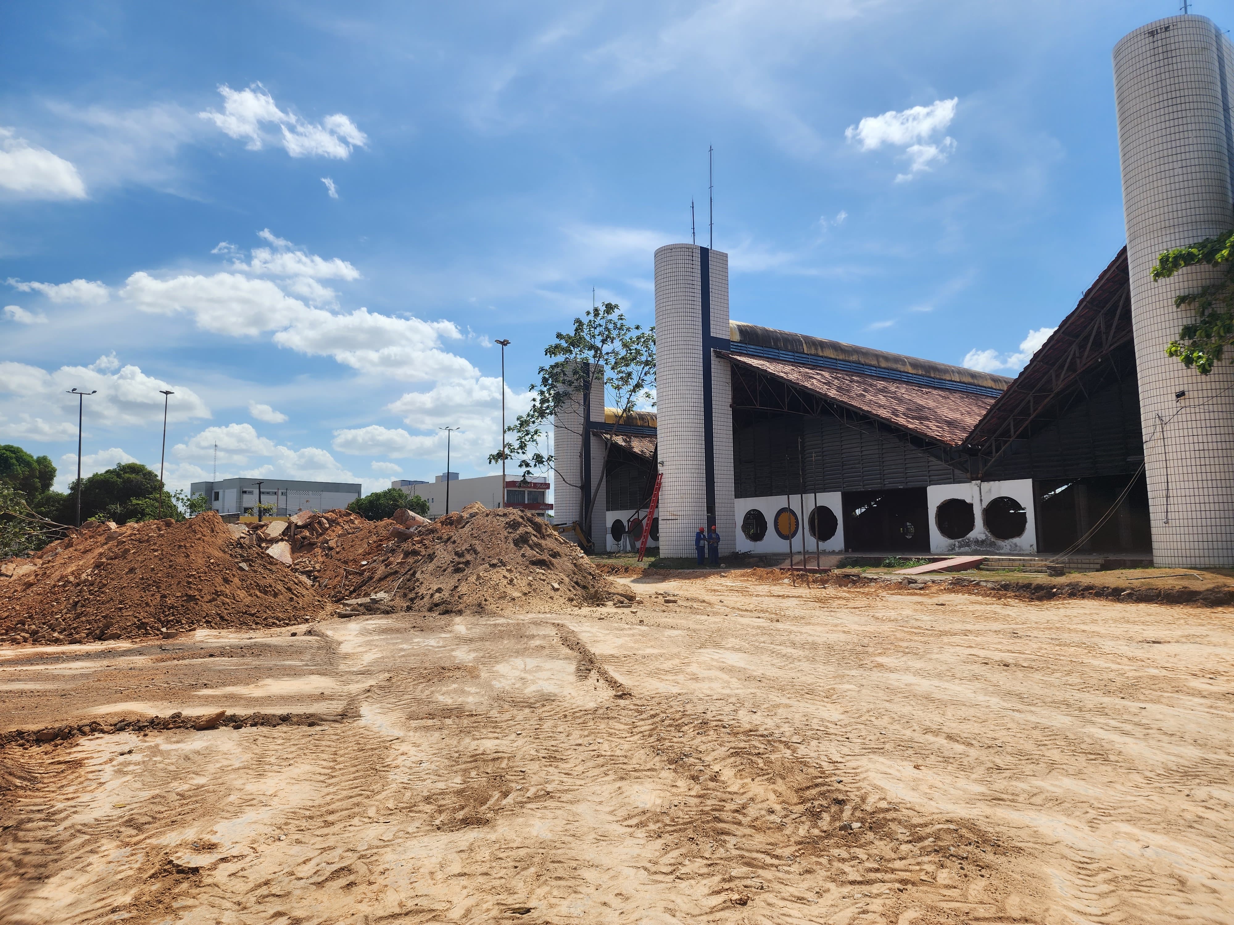 Foto colorida dos fundos do Palácio Latife Salomão em obras.  No lado esquerdo da foto há montes de areia que serão usados ​​para fazer a obra.