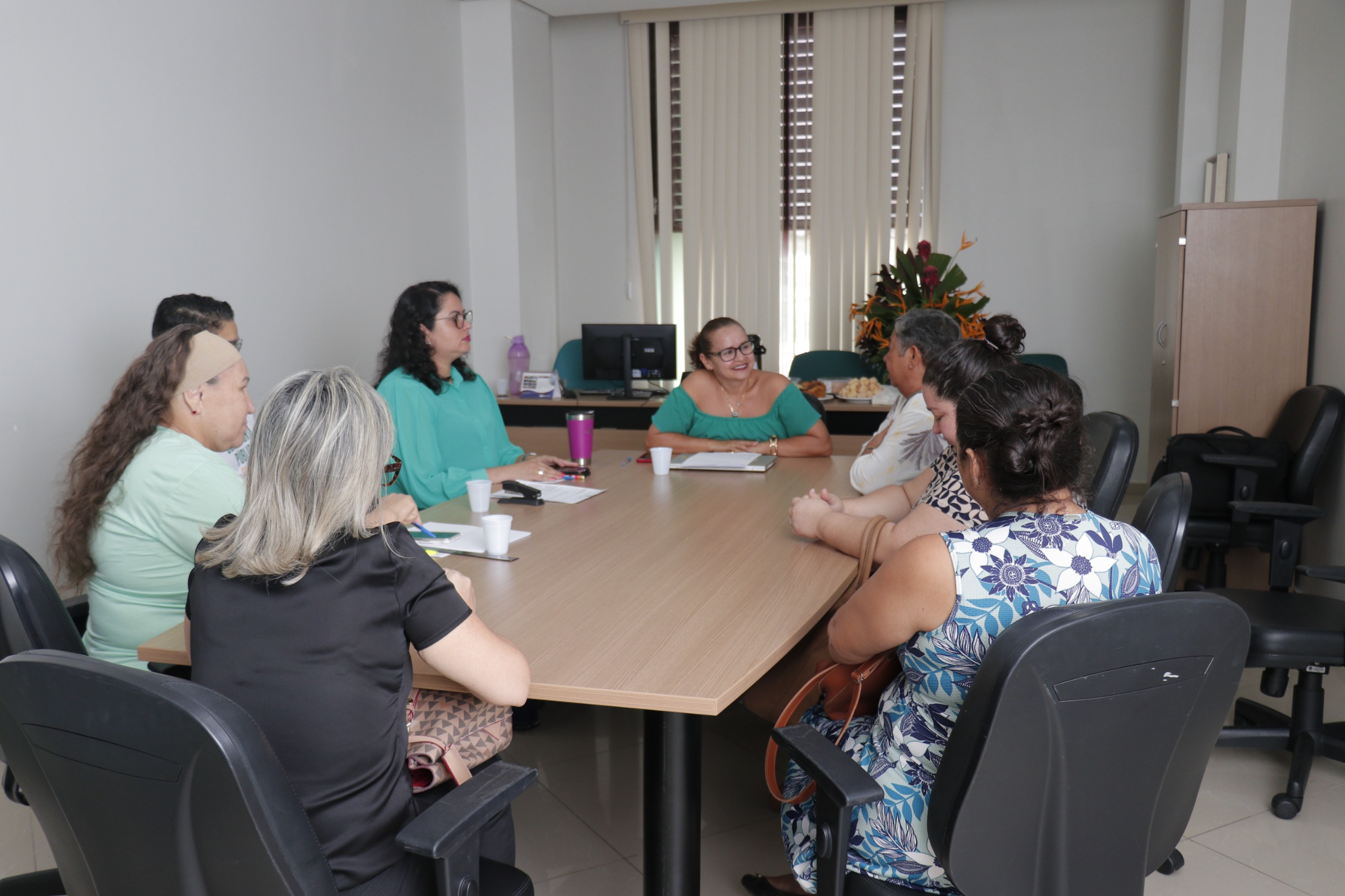 foto colorida de uma sala com a Juíza Graciete Sotto em reunião com uma família que estava registrando a paternidade.