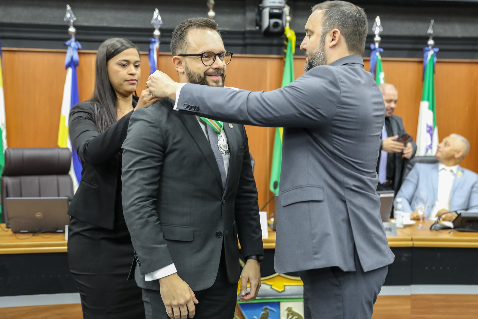 Foto colorida mostra o juiz auxiliar da presidência, Esdras Silva Benchimol recebendo a Medalha da Ordem do Mérito Legislativo.