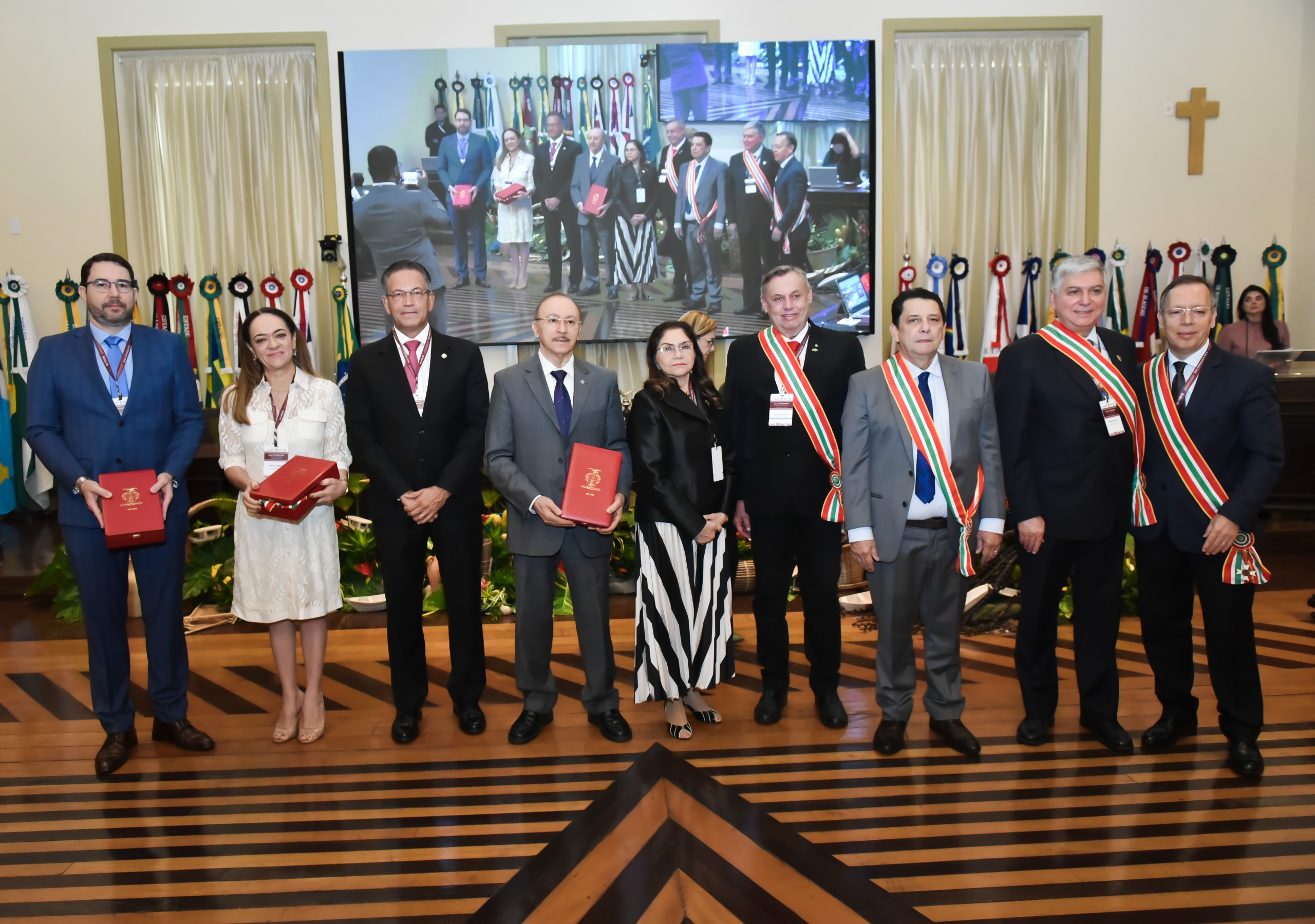 foto colorida Durante o XII Encontro do Consepre, realizado em Belém, com presidente do Tribunal de Justiça de Roraima (TJRR), desembargador Jésus Nascimento, pousando para fotografia com a  medalha Grã-Cruz da Ordem do Mérito Judiciário ao lado de outros homenageados pousando para fotografia