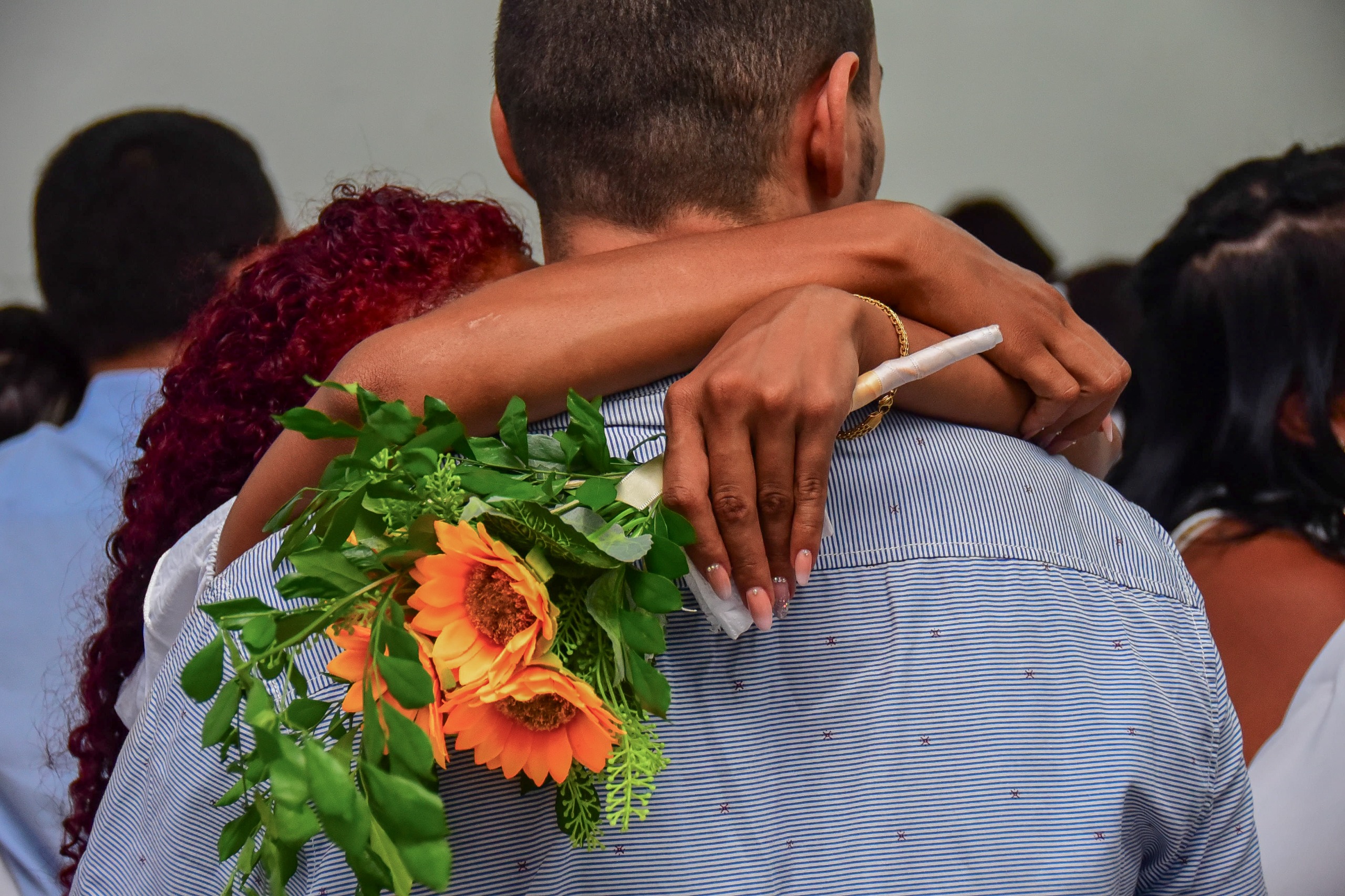 Casais oficializam uniões em casamento coletivo no Sistema Prisional. A foto mostra um casal abraçado. 