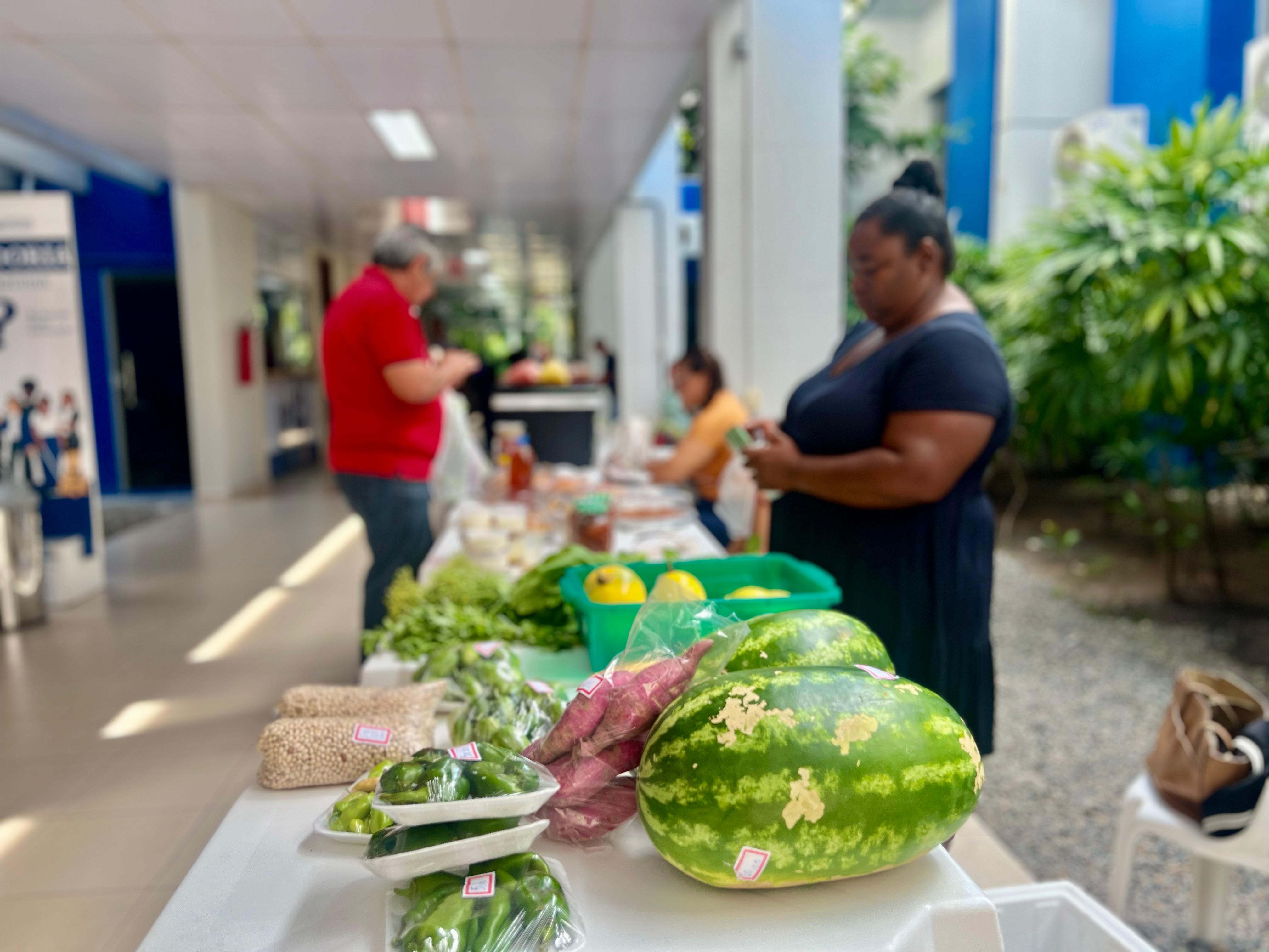 Foto colorida mostrando frutas e verduras em cima de uma mesa. 