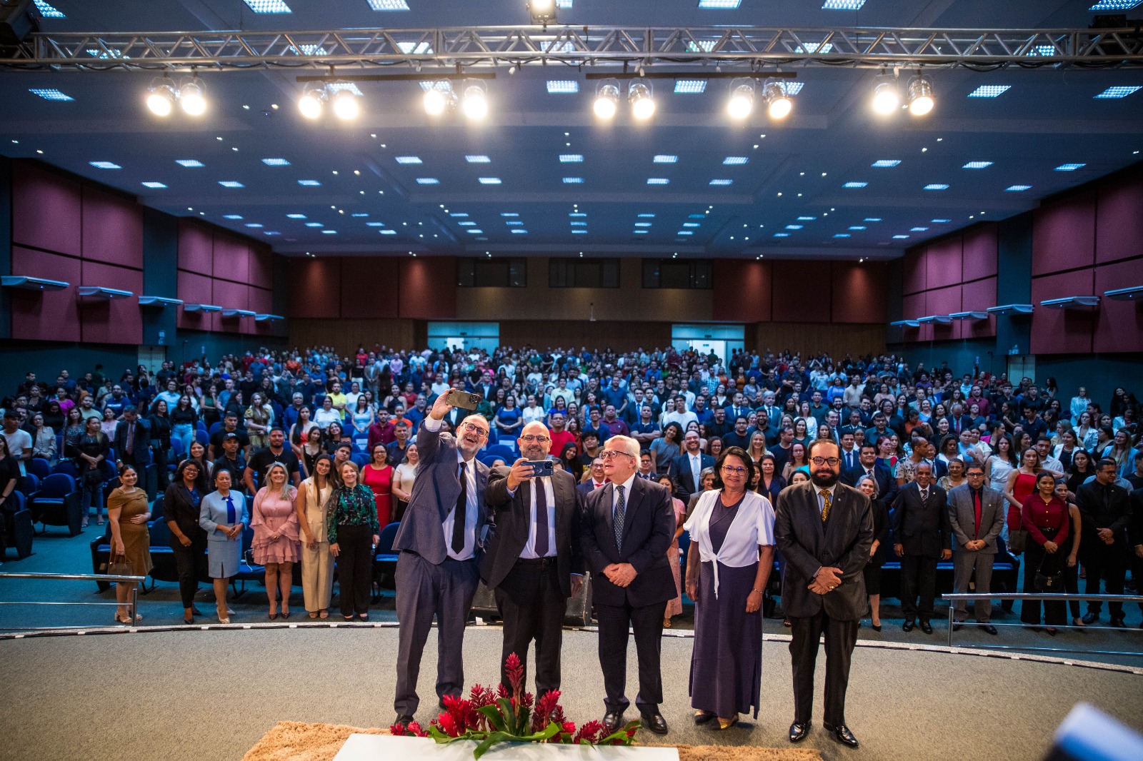 foto colorida com o  Presidente do Superior Tribunal de Justiça (STJ), Ministro Herman Benjamin, Ministro Sebastião Reis Júnior, Ministro Paulo Domingues,  o Presidente do Tribunal de Justiça de Roraima, Desembargador Leonardo Cupello e a Diretora da Ejurr Tânia Vasconcelos, pousando para a fotografia e ao fundo o público em pé no auditório pousando também para a fotografia. 