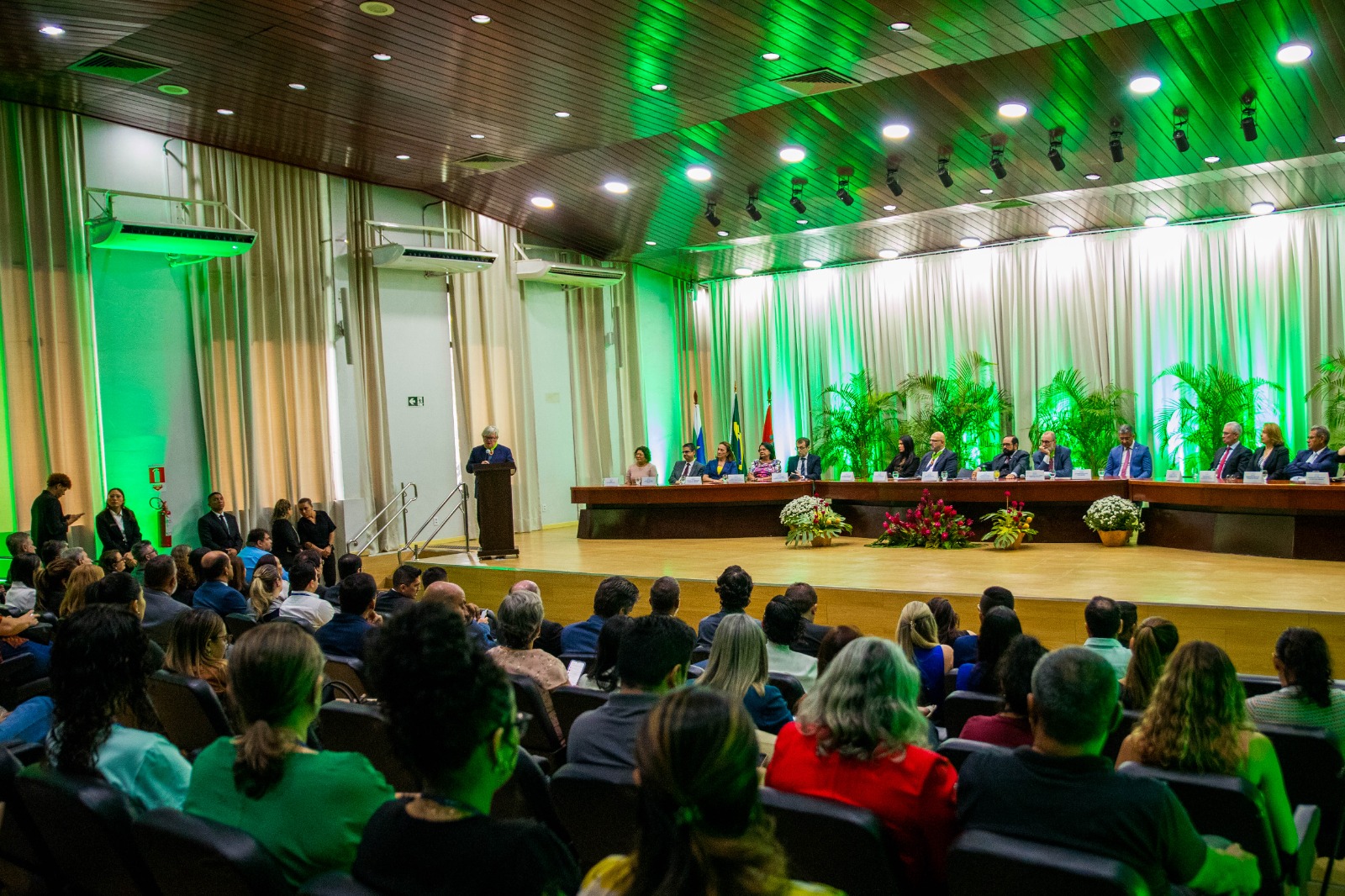 foto colorida do público no auditório, ao fundo está a mesa de autoridades e o Presidente do Superior Tribunal de Justiça (STJ) Herman Benjamin, discursando no púlpito. 