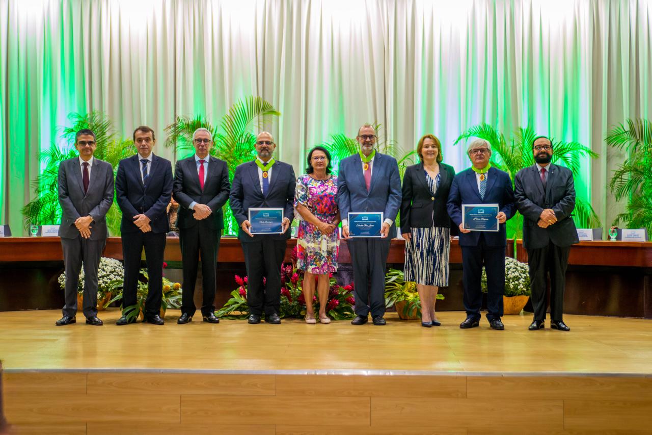 foto colorida com os ministros do Superior Tribunal de Justiça (STJ) Herman Benjamin, Sebastião Reis Júnior e Paulo Domingues posando para fotografia, segurando o certificado e cada um com sua medalha ao lado do Presidente do TJRR, Desembargador Leonardo Cupello, Desembargadora Elaine Bianchi, a Diretora da Escola Judicial de Roraima, Desembargadora Tânia Vasconcelo, o Desembargadores Ricardo Oliveira, e o Corregedor Geral, Erick Linhares. 