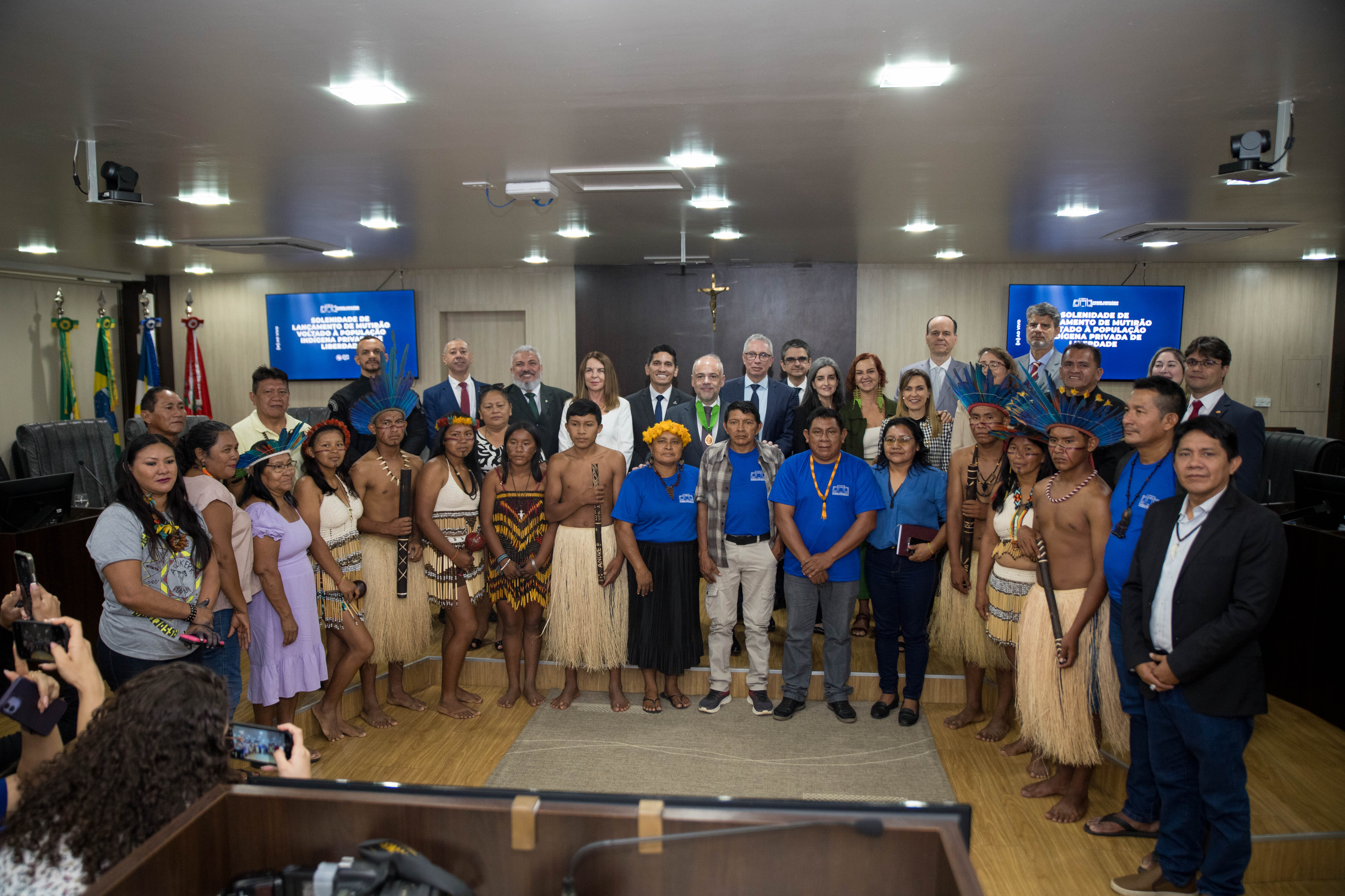 A imagem colorida retrata um grupo diversificado de 37 pessoas posando para uma fotografia na Sala de Sessões do Tribunal Pleno. A imagem colorida retrata um grupo diversificado de 37 pessoas posando para uma fotografia na Sala de Sessões do Tribunal Pleno.