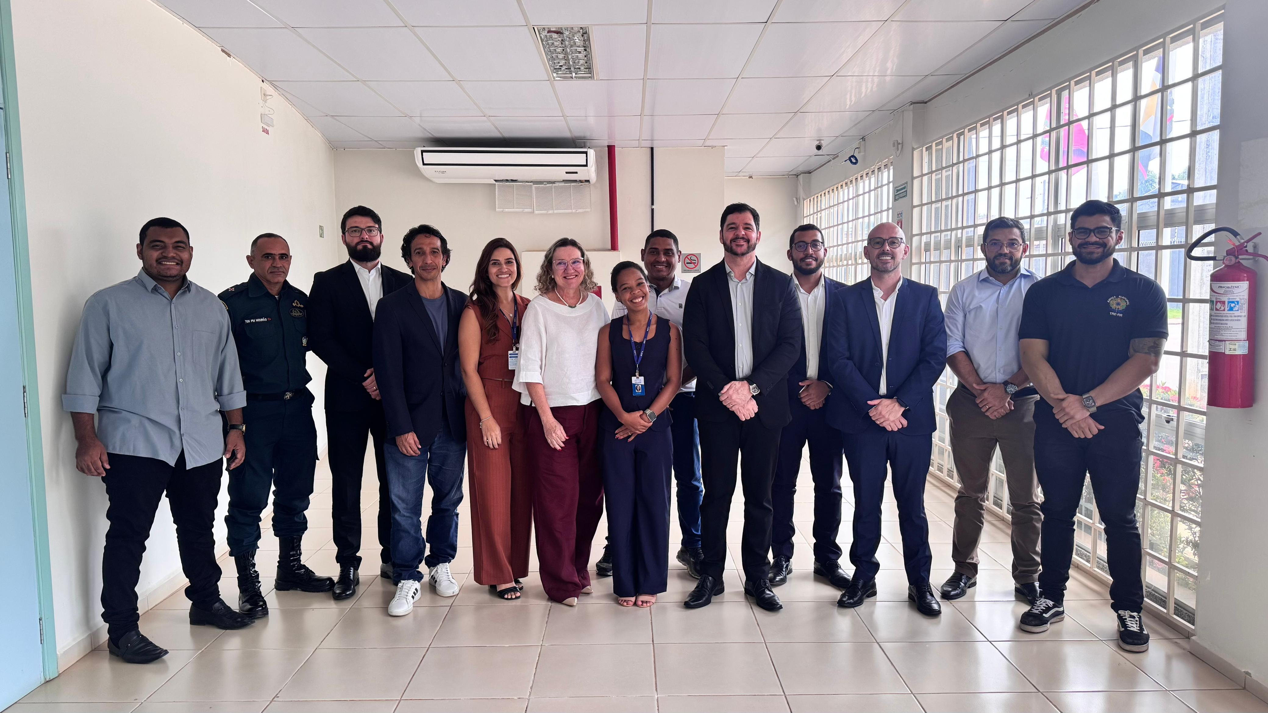 imagem colorida contém grupo de 13 pessoas posando para fotografia, entre eles encontra-se o superintendente da Polícia Federal, delegado Ronaldo Guilherme Campos; o delegado regional de Polícia Judiciária, Caio Luchini; o chefe da Delegacia de Repressão a Entorpecentes (DRE), Michel Saliba; e o chefe da Delegacia de Polícia de Imigração (Delepat), Marcelo Sobral. Também estiveram presentes o promotor de Justiça, Paulo André de Campos Trindade, e o comandante do 6º Pelotão da Polícia Militar, tenente Mourão, além de sete servidores da Justiça Estadual e Eleitoral. imagem colorida contém grupo de 13 pessoas posando para fotografia, entre eles encontra-se o superintendente da Polícia Federal, delegado Ronaldo Guilherme Campos; o delegado regional de Polícia Judiciária, Caio Luchini; o chefe da Delegacia de Repressão a Entorpecentes (DRE), Michel Saliba; e o chefe da Delegacia de Polícia de Imigração (Delepat), Marcelo Sobral. Também estiveram presentes o promotor de Justiça, Paulo André de Campos Trindade, e o comandante do 6º Pelotão da Polícia Militar, tenente Mourão, além de sete servidores da Justiça Estadual e Eleitoral.