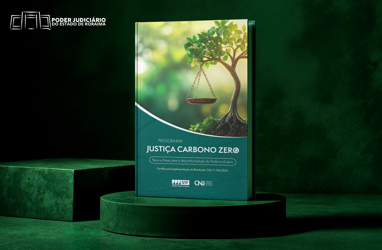 Imagem promocional com fundo verde escuro e a frase "ACESSE A CARTILHA" no topo. Ao centro, há um livro com a capa ilustrando uma balança da Justiça pendurada em um galho de árvore, simbolizando equilíbrio ambiental. O título do livro é "Justiça Carbono Zero", com subtítulo “Passo a passo para a descarbonização do Poder Judiciário”. Na parte inferior, aparecem os logotipos do STF, CNJ e do Poder Judiciário do Estado de Roraima.