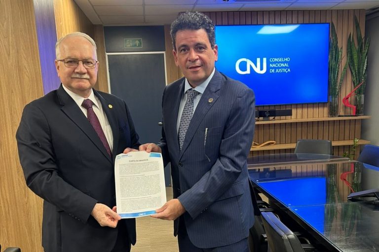 foto colorida mostra o presidente do Conselho Nacional de Justiça (CNJ) Ministro Edson Fachin, segurando carta ao lado do conselheiro do CNJ, Rodrigo Badaró.