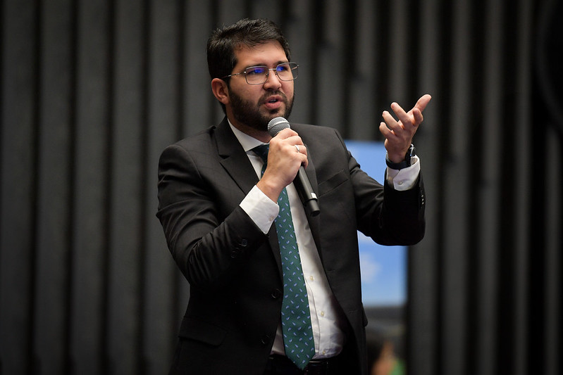 Imagem colorida contém o juiz de direito titular da Vara de Execução Penal, Daniel Damasceno, falando no microfone durante evento em Brasília. Imagem colorida contém o juiz de direito titular da Vara de Execução Penal, Daniel Damasceno, falando no microfone durante evento em Brasília.