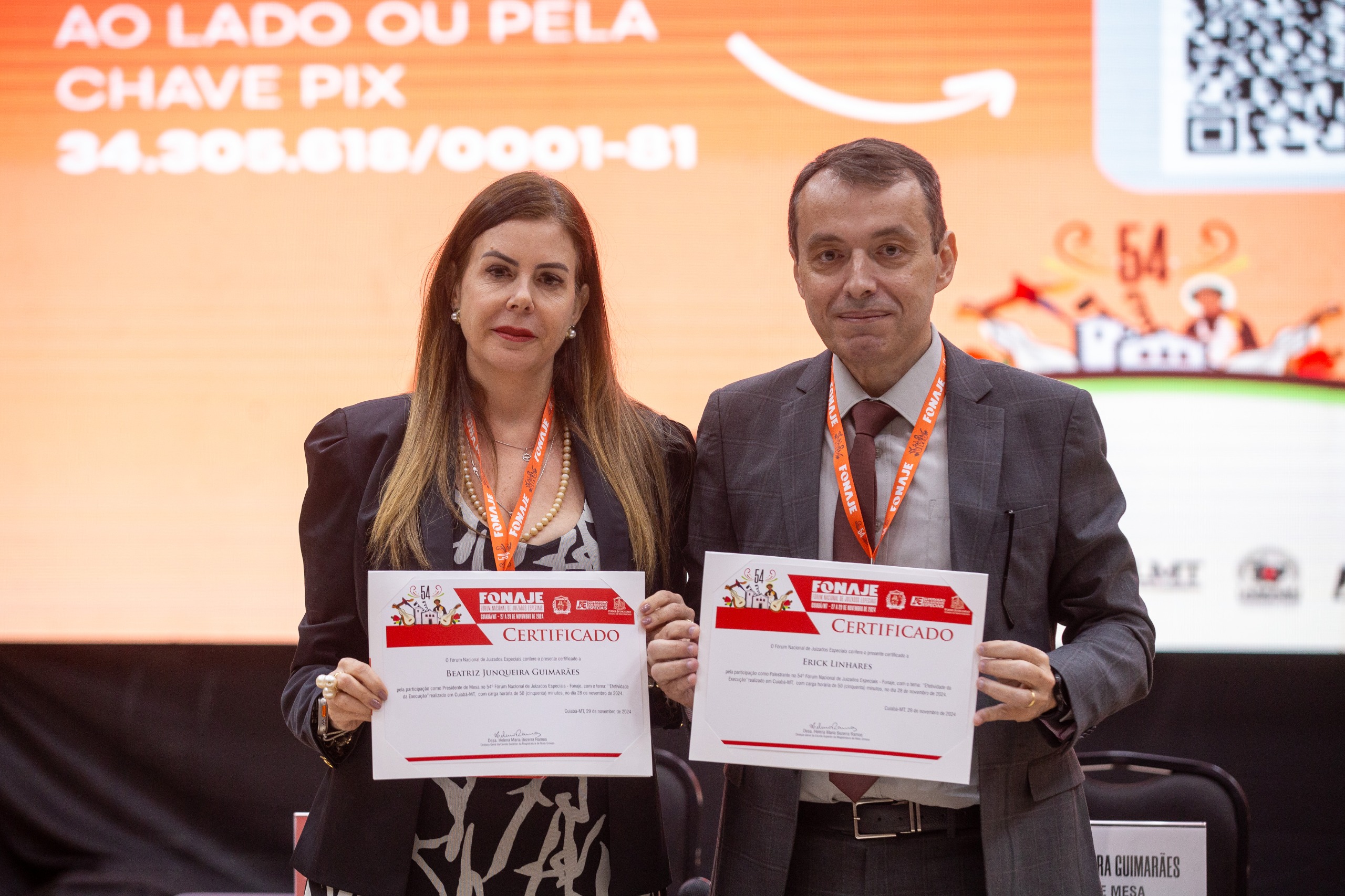 a imagem colorida mostra o Ouvidor-Geral do Tribunal de Justiça de Roraima, desembargador Erick Linhares, e a juíza Beatriz Junqueira Guimarães com certificados do Fonaje em mãos. Abaixo a frase: Desembargador Erick Linhares debate efetividade na execução durante o 54º Fonaje