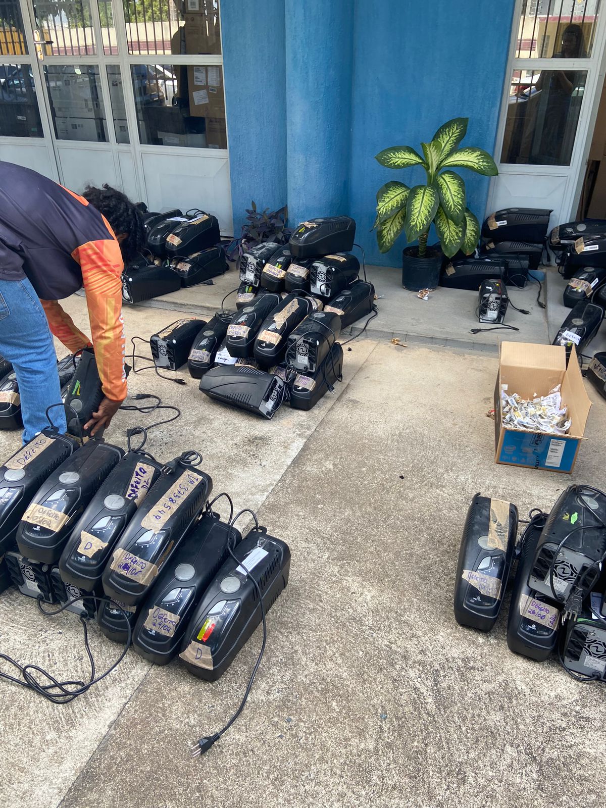 imagem colorida mostra uma pessoa organizando os equipamentos que serão descartados de forma correta.