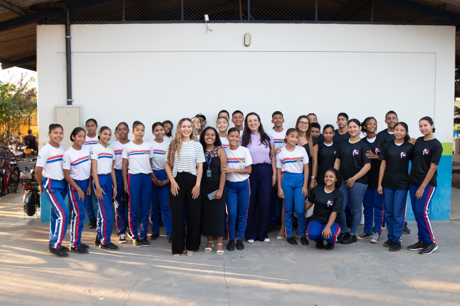  A imagem colorida mostra integrantes da ação de 21 dias ao lado de alunos do ensino fundamental, perfilados para foto