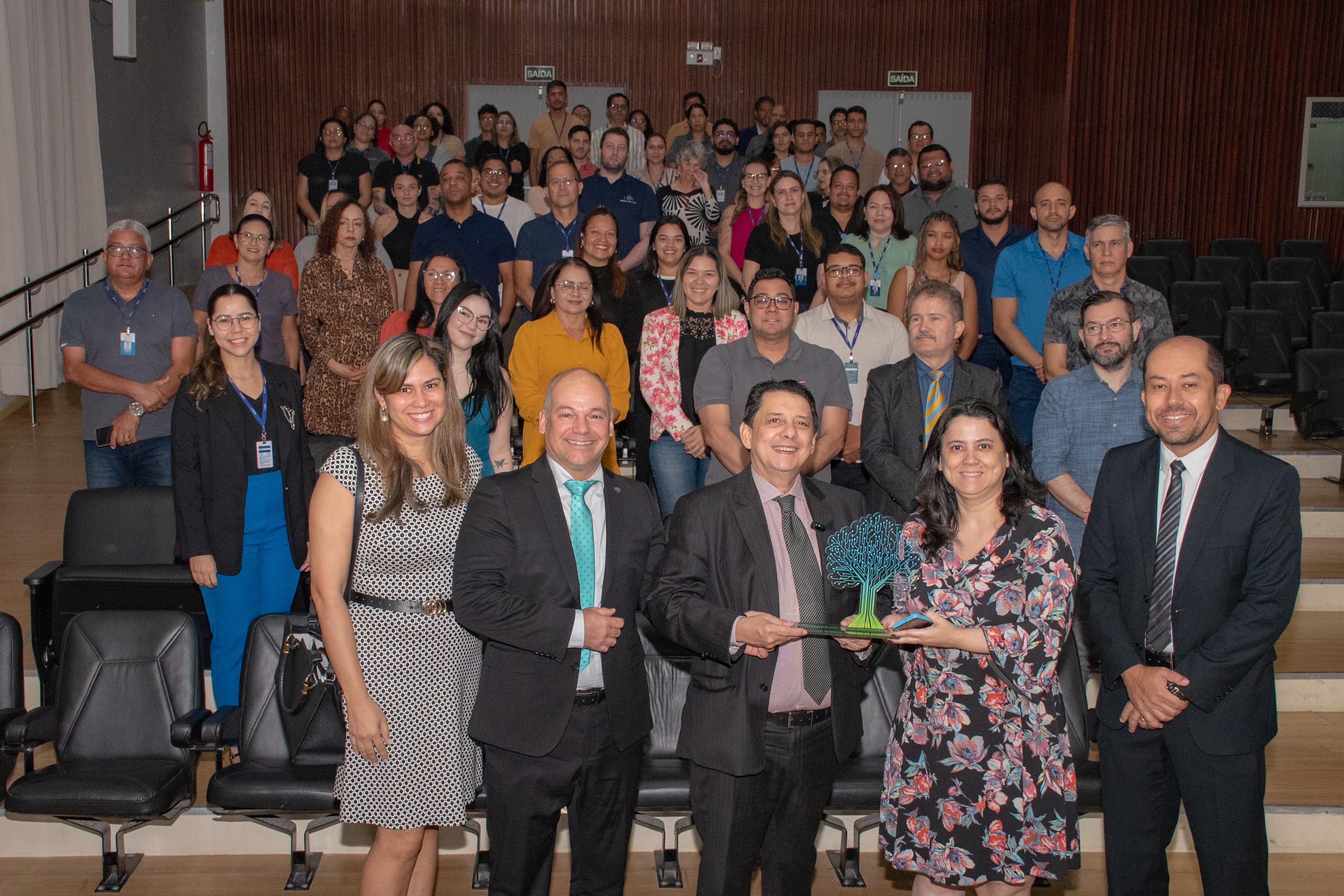 Imagem colorida mostra o presidente do TJRR, desembargador Jésus Nascimento, palestrando para publico de magistrados, servidores, estagiários e colaboradores do TJRR, no auditório do Fórum Cível Advogado Sobral Pinto. Em suas mãos está o microfone. Abaixo a frase “PRÊMIO EXCELÊNCIA: Presidente destaca atuação do Judiciário roraimense na conquista do Prêmio CNJ de Qualidade 2024”.