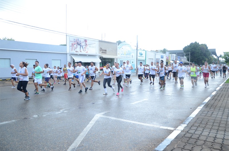 A imagem colorida mostra dezenas de participantes da corrida durante o exercício, alguns olham para a câmera com sorrisos. Abaixo a frase: Tribunal de Justiça de Roraima realizará 3ª Edição da corrida de rua "Volta Jurídica"