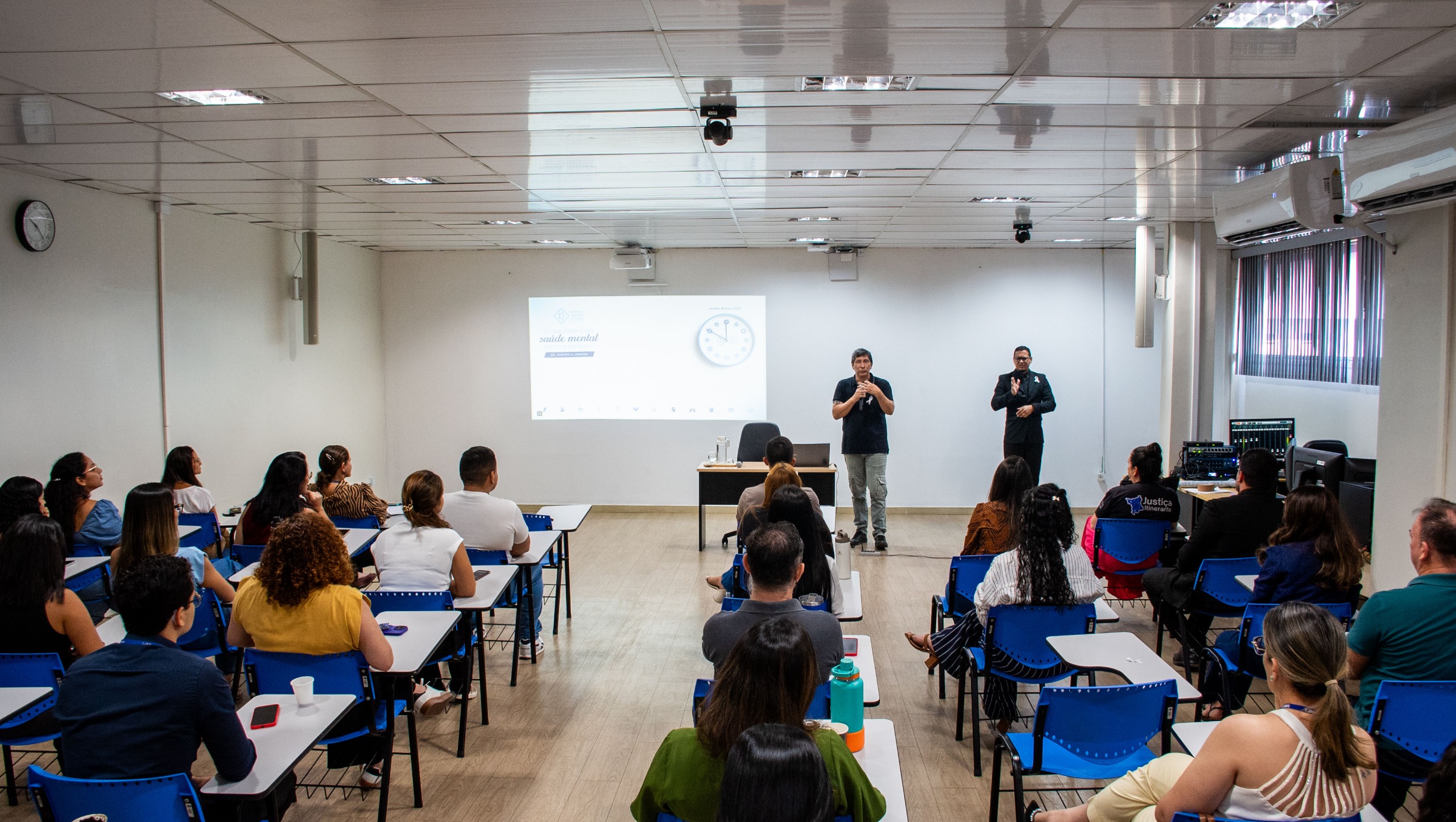  imagem colorida mostra integrantes do TJRR assistindo palestra sobre saúde mental, que ocorreu na EJURR. A foto foi tirada com o público de costas para a câmera. Na imagem contém 22 pessoas. Abaixo a frase “JANEIRO BRANCO - Palestra destaca a importância do cuidado com a saúde mental para uma vida equilibrada.”